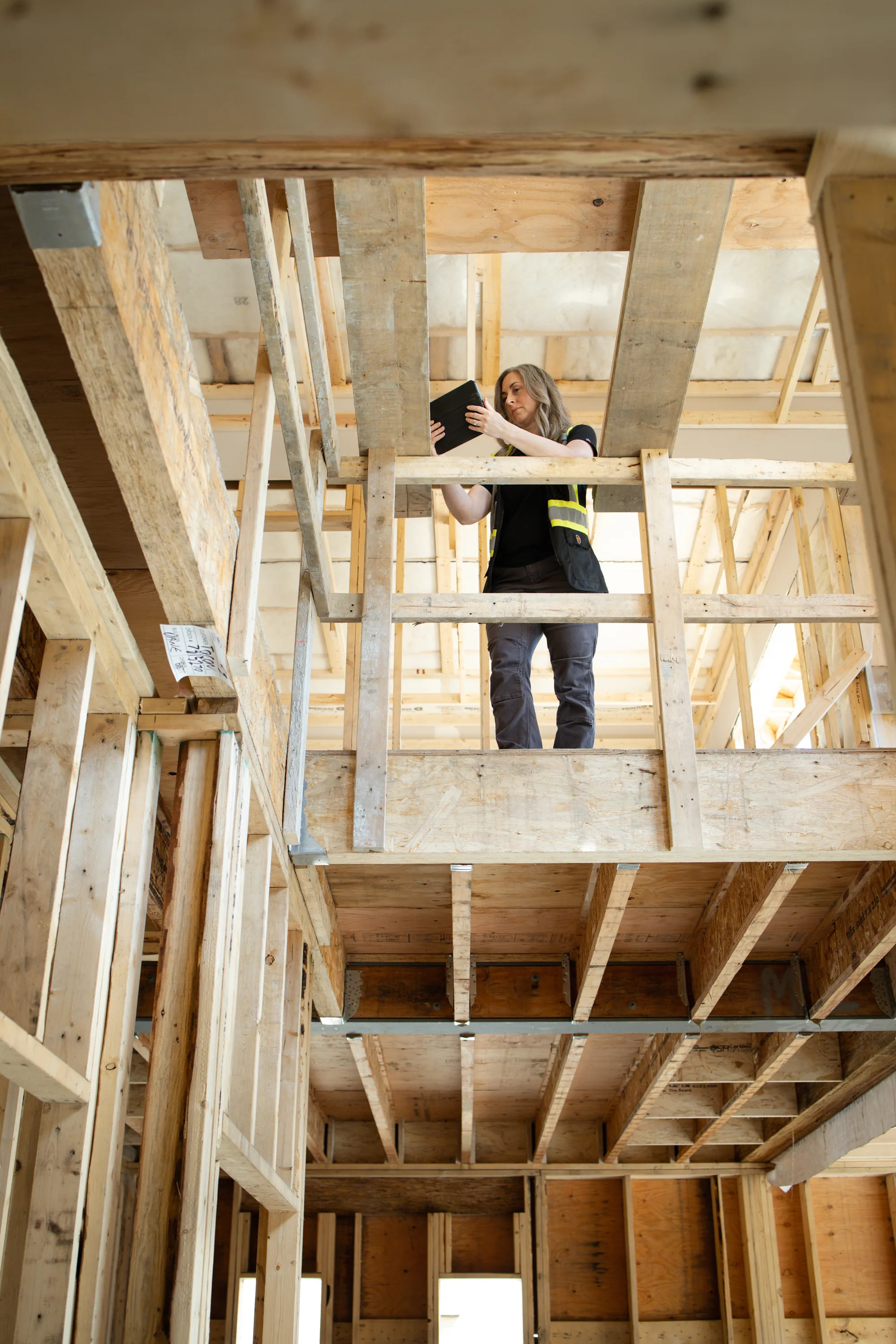 Rebecca Sorbara working between the framed floors of a residential home under construction