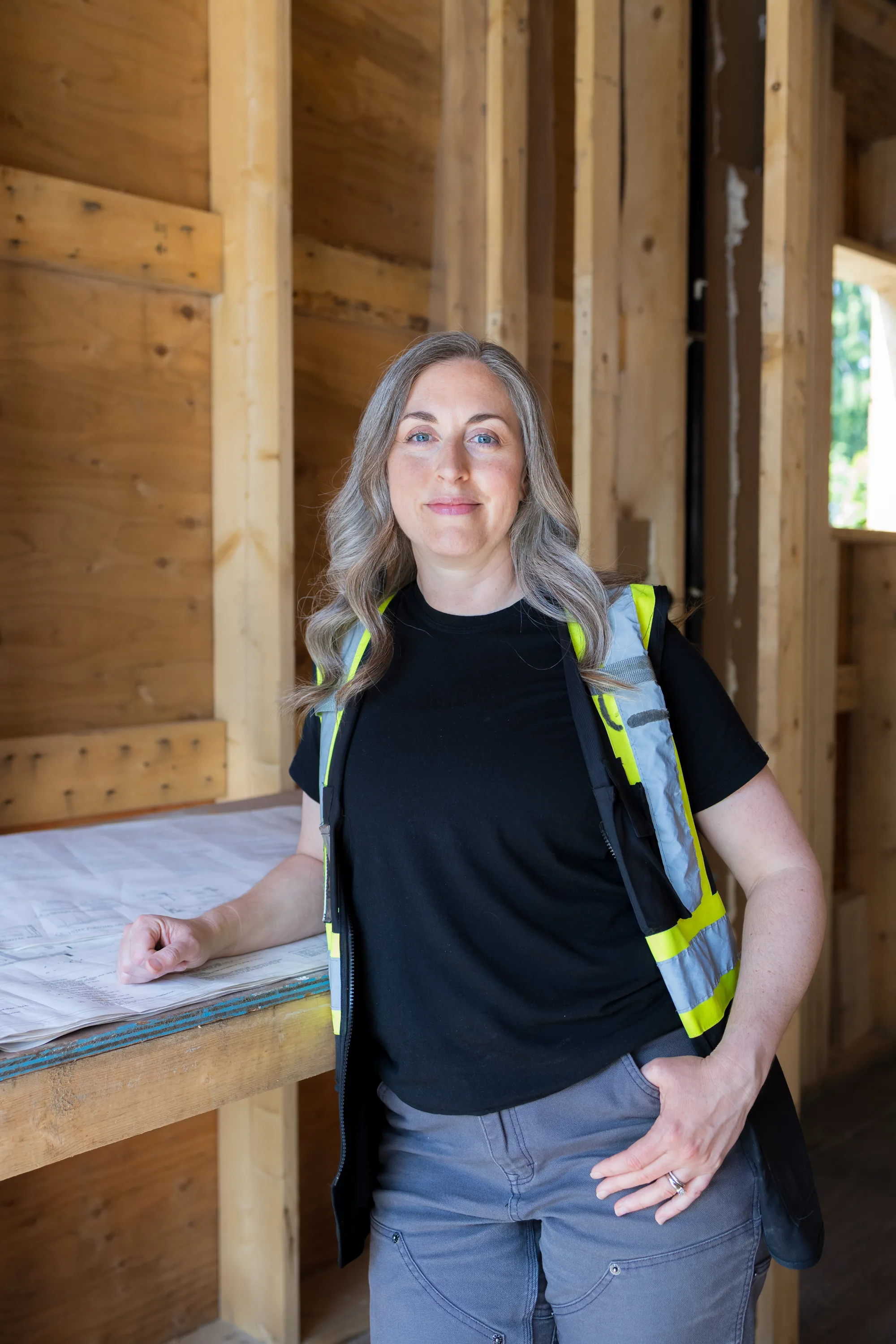 Rebecca Sorbara, founder of Montsera Permit Solutions, standing in a wood-framed home under construction