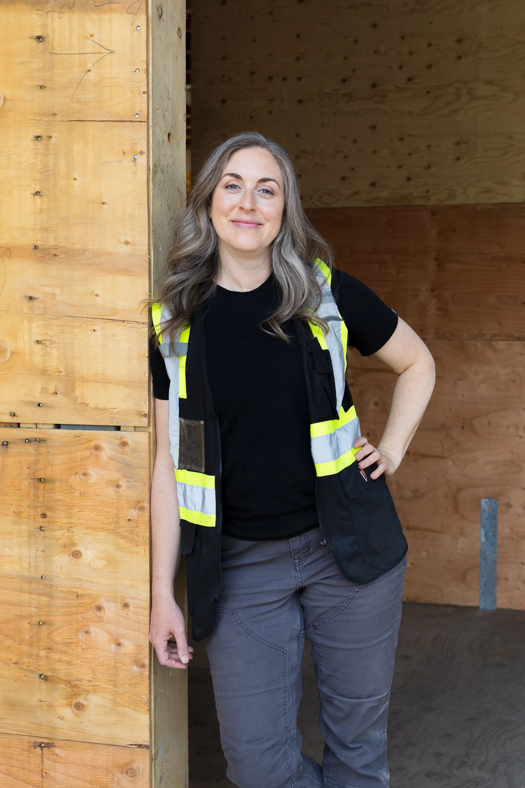 Rebecca Sorbara standing confidently in the framed doorway of a home under construction